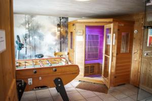 a bathroom with a wooden tub and a purple door at Chalet entier, vue panoramique, ruisseau et sauna. in Bussang