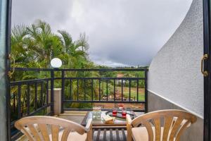 a balcony with a table and chairs and a view at Yash villa - 2 Bhk ll Private pool ll Wifi ll Tv ll in Lonavala