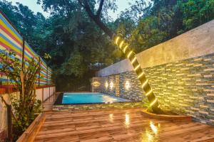 a swimming pool with a string of lights next to a brick wall at Yash villa - 2 Bhk ll Private pool ll Wifi ll Tv ll in Lonavala