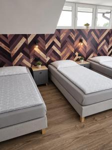 a bedroom with two beds and two windows at Pokoje Hotelowe Gościniec in Siedlce