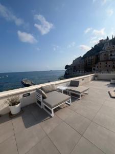 a patio with two chairs and a table and the ocean at Marefuori Suite in Minori