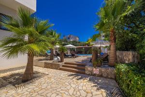 a resort with palm trees and a swimming pool at Villa Palma Krk in Krk