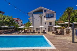 a villa with a swimming pool in front of a house at Villa Palma Krk in Krk