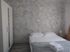 a bedroom with a white bed and a stone wall at Apartament Clau Centru Vechi in Constanţa +5 photos