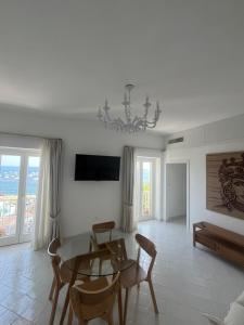 a living room with a table and chairs and a chandelier at Marefuori Suite in Minori