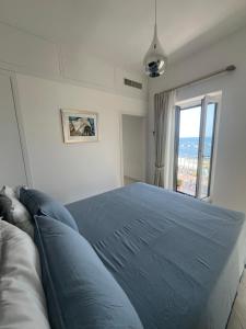 a bedroom with a large blue bed with a window at Marefuori Suite in Minori