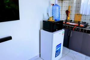 a microwave on top of a refrigerator in a kitchen at Soft stay homes in Mombasa