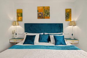 a bedroom with a large white bed with blue pillows at casa Jardín del sol planta alta in Tacoronte