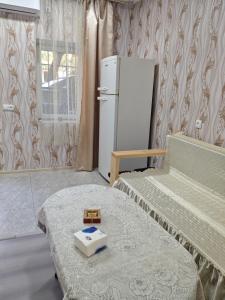 a room with a refrigerator and a table with a book at Vardan's Guest House in Yerevan