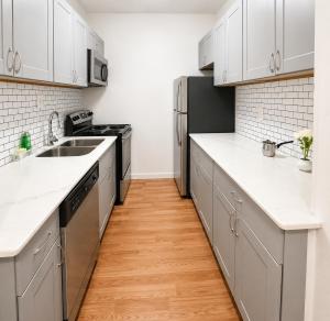 a kitchen with white cabinets and a wooden floor at Convention District Studio - Downtown Houston in Houston