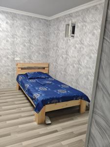 a bedroom with a bed with a blue comforter at Vardan's Guest House in Yerevan