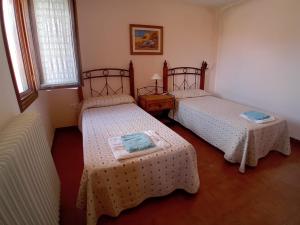 two beds in a room with two tables at Casa Flor de Rello in Rello