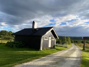 a small black building on the side of a road at Tørresvangen in Tynset +14 photos