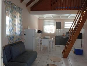 a living room with a couch and a kitchen at Résidence des Pikaniers in Anse-Bertrand