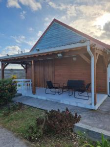 a pavilion with chairs and a table on a patio at Résidence des Pikaniers in Anse-Bertrand