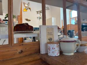 a counter with a shelf with cakes and cups on it at L'auberge de la Ludogare in Saillagouse