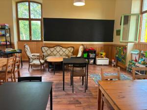 a classroom with tables and chairs and a blackboard at L'auberge de la Ludogare in Saillagouse +24 photos