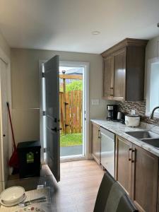 a kitchen with a stainless steel refrigerator and a door at Happy Homes in St. John's