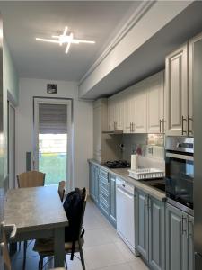 a kitchen with white cabinets and a table and a dining room at Tomorrowland Residence in Boom +13 photos