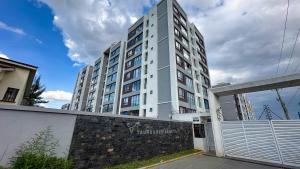 a tall white building with a fence in front of it at Ultimate Safari Retreat,9min to Nairobi JKIA with Pool,Gym,WiFi and Binocular views in Nairobi