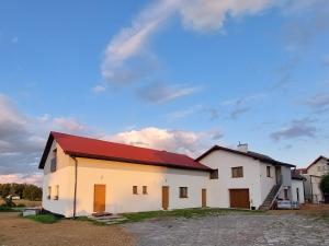 a large white building with a red roof at Nowy Zakątek in Paszkówka