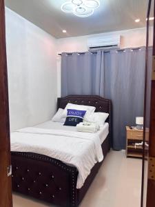 a bedroom with a bed with a blue curtain at Next House Passi City in Iprog