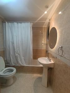 a bathroom with a toilet and a sink and a tub at Kairos in Buenos Aires