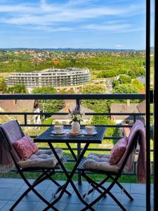 a table and chairs on a balcony with a view at Savelij apartament in Hévíz