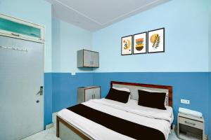a blue room with a bed and a blue wall at Hotel O Urban Rooms in Neemrana