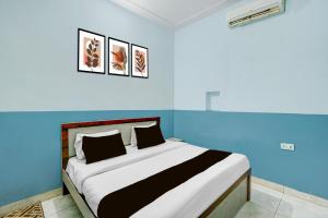 a bed in a room with a blue wall at Hotel O Urban Rooms in Neemrana