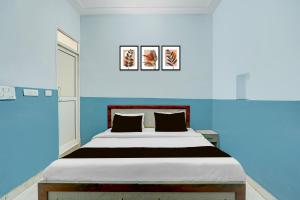 a bedroom with a large bed with blue walls at Hotel O Urban Rooms in Neemrana