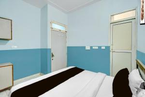 a blue and white bedroom with a bed and a door at Hotel O Urban Rooms in Neemrana +50 photos