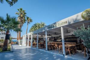 a restaurant on the beach with palm trees at Ondo Beach & Suites in Bodrum City +35 photos