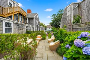 a garden with benches and flowers in front of houses at Carlisle House Inn in Nantucket