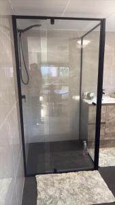 a glass shower door in a room with a rug at Family Friendly One Bedroom Studio in Brisbane