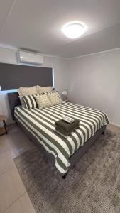 a bedroom with a large bed with a black and white stripes at Family Friendly One Bedroom Studio in Brisbane
