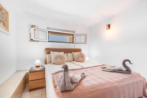 a bedroom with a bed with two swans on it at Moser Living Premium Apartments - Puerto Rico in Mogán +34 photos