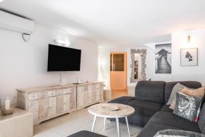 a living room with a couch and a tv on a wall at Moser Living Premium Apartments - Puerto Rico in Mogán