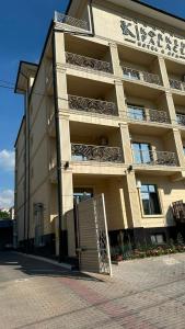 a large building with a gate in front of it at Palace&Spa Rooms in Shymkent