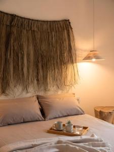 a bed with a tray with two cups on it at Casa Centro in Hervás