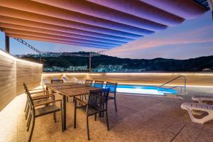 a table and chairs on a balcony with a pool at Moser Living Premium Apartments - Puerto Rico in Mogán