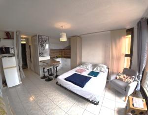 a bedroom with a bed and a table and a desk at Charmant studio Toi et Moi à 30 m de la plage et de Valras centre avec linge de lit et ménage inclus in Valras-Plage