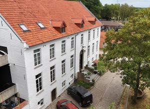 an aerial view of a large white building with an orange roof at Orange Parkway Hotel in Diest