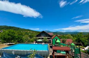 a swimming pool in front of a house at Casa Popescu Calimanesti Caciulata in Călimăneşti