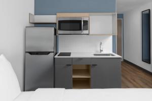 a small kitchen with a refrigerator and a sink at StudioRes by Marriott Clearfield Layton in Clearfield +9 photos