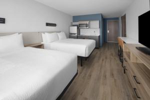 a hotel room with two beds and a flat screen tv at StudioRes by Marriott Clearfield Layton in Clearfield