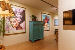 a room with paintings on the wall and a green cabinet at Droom op de Vijlenberg in Vijlen