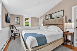 a bedroom with a large bed and a chair at Carlisle House Inn in Nantucket