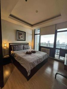 a bedroom with a large bed with a large window at Azure Urban Resort Residences St Tropez Tower Near SM Bicutan with Wave Pool in Manila +41 photos
