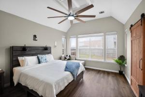 a bedroom with a large bed and a ceiling fan at Spacious 4BR Retreat |Pool Table| Firepit & Hottub in Kyle +59 photos